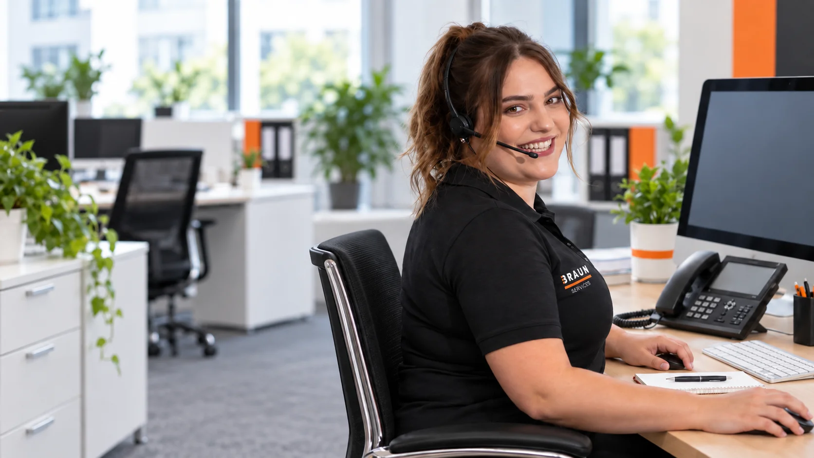 Lächelnde Ansprechpartnerin mit Headset im BRAUN Büro.