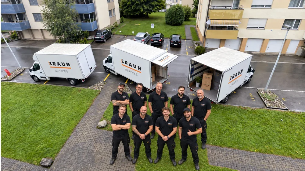 Das BRAUN-Team vor drei Umzugswagen, von oben fotografiert.