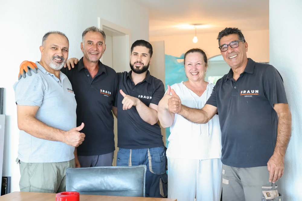 Das BRAUN-Team und seine Kunden zeigen nach dem Umzug gemeinsam den Daumen nach oben.